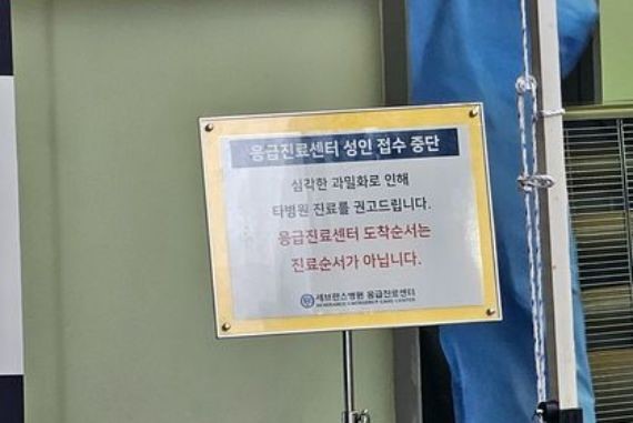 图为19日上午在首尔西大门区SEVERANCE医院急诊室前贴出的“因患者过度密集暂停接诊”的告示。【照片来源：李赞揆 记者】