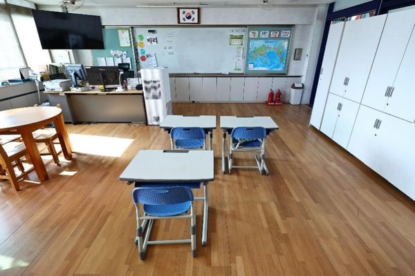 图为在学生越来越少的临东小学5年级教室里按照学生人数摆放的3张课桌。【摄影：金钟昊 记者】