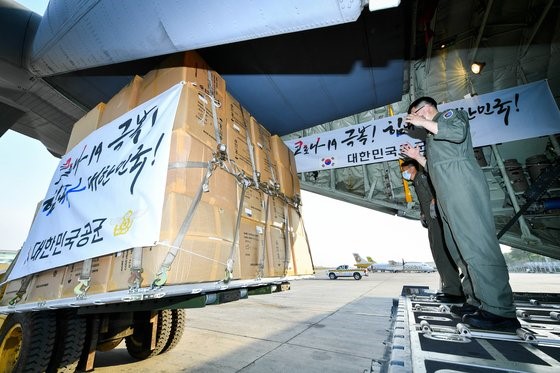 图为今年3月18日(当地时间)，韩国空军第五空中机动飞行团的官兵正在缅甸仰光国际机场往C-130J运输机上装载防疫物资。【照片由韩国空军提供】