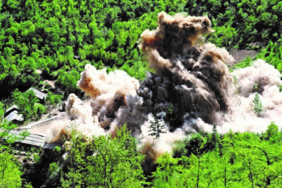 2018年11月24日，朝鲜核武器研究所的相关人员对咸镜北道吉州郡丰溪里核试验场进行了爆破作业。图为丰溪里核试验管理指挥所被引爆后，木制建筑瞬间灰飞烟灭。【照片来自联合记者团】