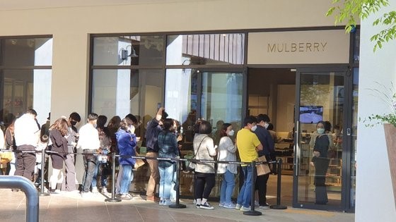 图为5月5日，现代高端奥特莱斯金浦店某名牌商店门前，消费者正在排队等待入场。【照片由现代百货商店提供】