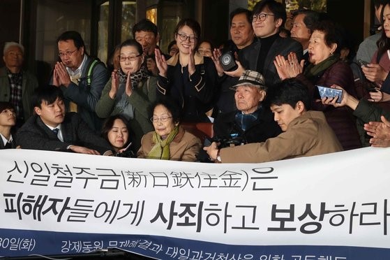 图为2018年10月30日韩国大法院作出判决之后，日本强征劳工受害者李春植爷爷(94岁，前排右二)做出了感谢的手势。【中央图库】
