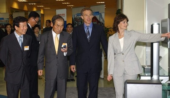 图为2003年7月访韩的时任英国首相布莱尔(左三)访问了韩国和英国的合资企业三星Homeplus永登浦店，在三星电子前副总裁尹钟龙(左二)、三星Tesco前总经理李承焕(左)的带领下正在参观卖场。【中央图片库】