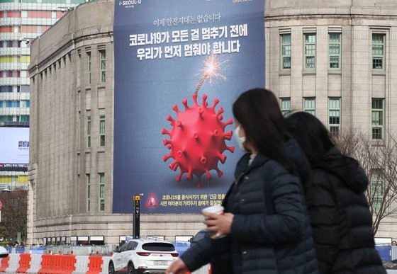 12月25日首尔市政府图书馆外墙挂出了巨幅宣传图，号召千万市民紧急“暂停”。【俞尚祖 记者】