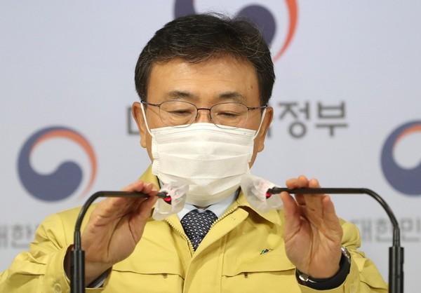 12月27日，韩国保健福祉部部长权德喆在首尔钟路区政府首尔办公大楼发布中央灾难安全对策本部应对新冠疫情的会议结果。图为权德喆部长正在会前调节麦克风位置。【林铉东 记者】