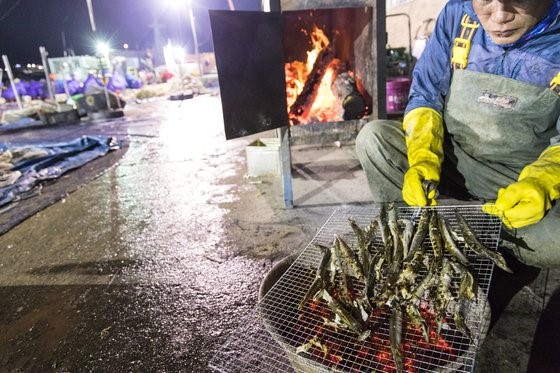 渔民深夜在玉筋鱼码头的一角点起炭火烤玉筋鱼。崔昇杓 记者