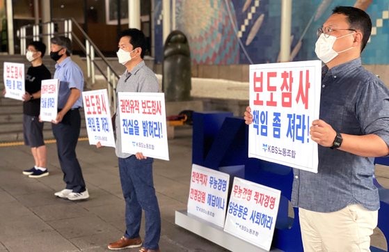 图为2019年7月23日上午在首尔汝矣岛KBS电视台大楼，KBS工会成员们对电视台误报"检媒勾结"一事高举要求对此问责的牌子。【照片来源：韩联社】