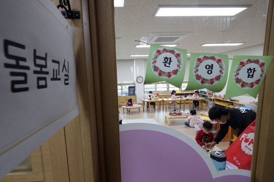 图为去年3月30日在光州广域市某幼儿园紧急看护教室的老师正在和孩子一起玩耍学习。【照片来源：韩联社】