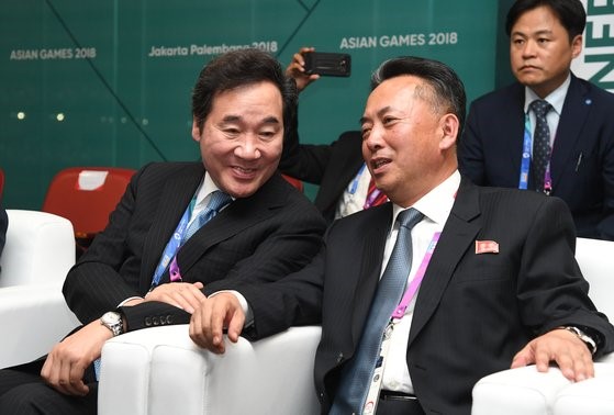 图为2018年8月，出席印度尼西亚雅加达亚运会开幕式的韩国国务总理李洛渊和朝鲜内阁副总理李龙男(以上为两人当时的职务)正在谈话。【照片来源：韩联社】 