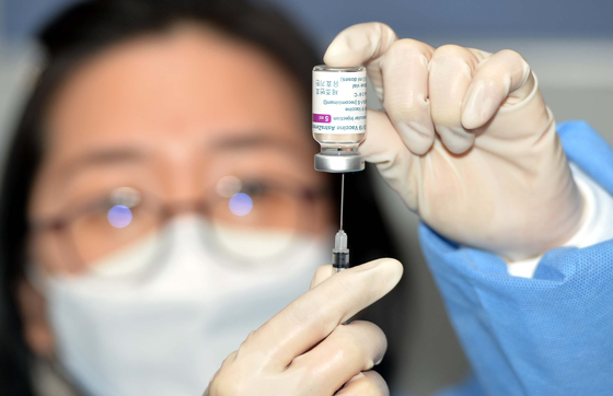 图为在大田儒城区卫生所，医务人员正用专用注射器从疫苗瓶中抽出疫苗。【自由撰稿人 金成泰】