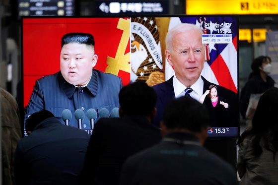图为3月26日在首尔市内某大型电视屏幕上，美国总统拜登和朝鲜国务委员长金正恩同时出现在屏幕上。【美联社=韩联社】