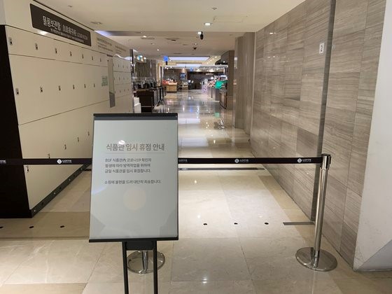5月5日，首尔小公洞乐天百货店总店食品馆入口处贴出告示，表示因店内出现新冠肺炎确诊患者暂停营业的告示。【照片来源：韩联社】
