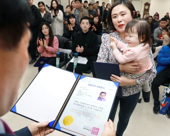 图为2019年一名外国人和子女正在领取大韩民国国籍证书。 【照片来源：NEWS 1】