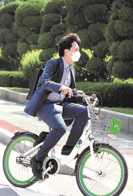 图为6月13日上午，国民之力党新党首李俊锡骑着共享单车到首尔永登浦区国会议事堂开始上班。【吴宗铎 记者】