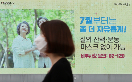 图为6月30日上午在首尔市厅某电子广告牌上还显示着7月起打完疫苗的人可以在室外免戴口罩的字样。【照片来源：NEWS1】