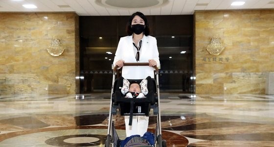 图为7月5日，韩国基本所得党议员龙慧仁用婴儿车推着两个月的儿子到首尔永登浦区国会大楼上班，图为其正在经过国会大会会场。林铉东 记者