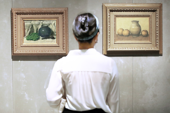 7月6日在首尔国立现代美术馆德寿宫馆举行的《DNA：韩国美术的昨日和今天》媒体公开会上，一位参观者正在欣赏三星集团董事长李健熙收藏的都相凤作品《葡萄坛子静物》(左)和《静物A》。这次展览从7月8日起向普通观众开放。【照片来源：韩联社】