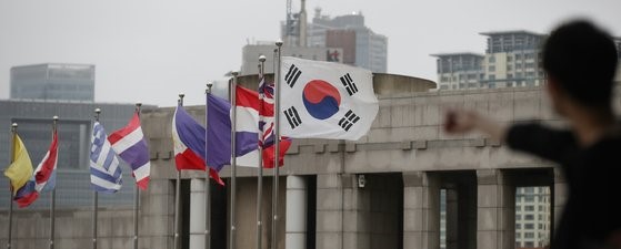图为首尔龙山区战争纪念馆门前飘扬着韩国和多国国旗。【照片来源：韩联社】