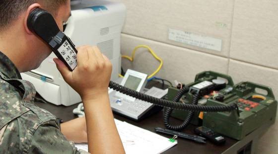 图为韩国军方人士正在与朝鲜通电话。【照片来源：韩联社】