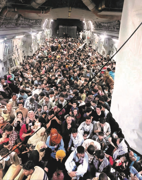 8月15日(当地时间)，逃离阿富汗的640名阿富汗人密密麻麻地坐在美国空军C-17运输机上。该型号运输机的正常限载人数为134人，阿富汗人坐在后方的载货舱内。【照片来源：路透社、美联社、韩联社】