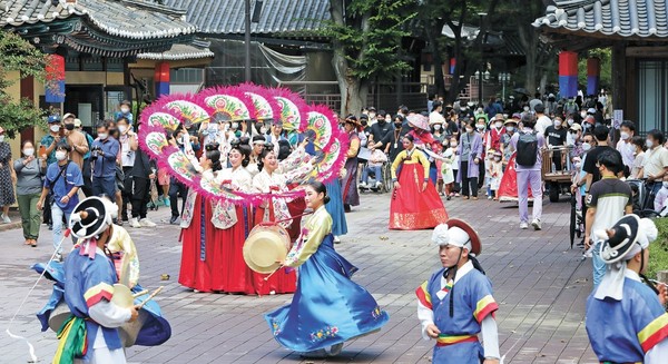 图为22日下午在韩国中秋节假期的最后一天来到京畿道龙仁市器兴区韩国民俗村的市民们正在观看演出。【照片来源：NEWS1】