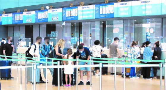 随着对完成新冠疫苗接种者的隔离豁免政策进一步放宽，前往境外旅行的游客数也在不断增加。 图为10月4日，在仁川机场第2航站楼值机柜台，乘客们正在办理手续。【照片来源：韩联社】