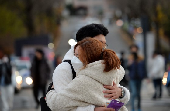 18日下午，韩国2022年大学修学能力考试结束，图为大田大信高中顺利结束考试的考生们正在与前来迎接的家人拥抱。【金成太 记者】