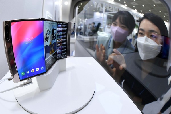 今年8月“韩国显示器产业展览会”的三星显示(Samsung Display)公司展位上，有关人士正在参观可以呈S字形折叠两次的“Flex in and Out折叠屏”。【照片来源：韩联社】
