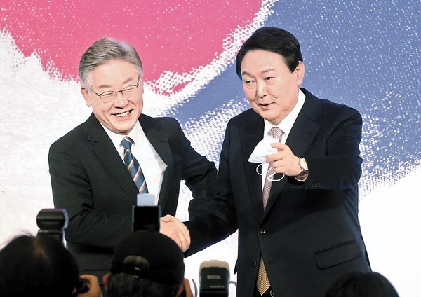 2021年中央论坛于11月24日上午在首尔钟路区四季酒店举行。当日国民之力党总统候选人尹锡悦(左)和民主党总统候选人李在明正在握手。【姜正贤 记者】