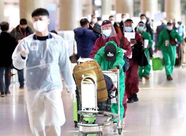 图为11月28日，仁川机场身穿防疫服的海外入境人员正在移动。【照片来源：NEWS1】