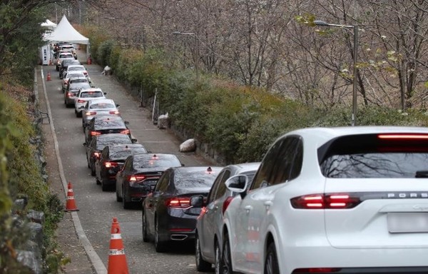 图为12月2日，在首尔瑞草区“得来速”新冠临时检查站前的车辆排起了长队。【照片来源：韩联社】