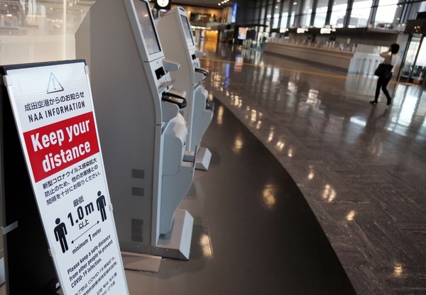 图为11月30日，在日本成田国际机场设置了提醒人们保持距离的指示牌。【照片来源：韩联社】