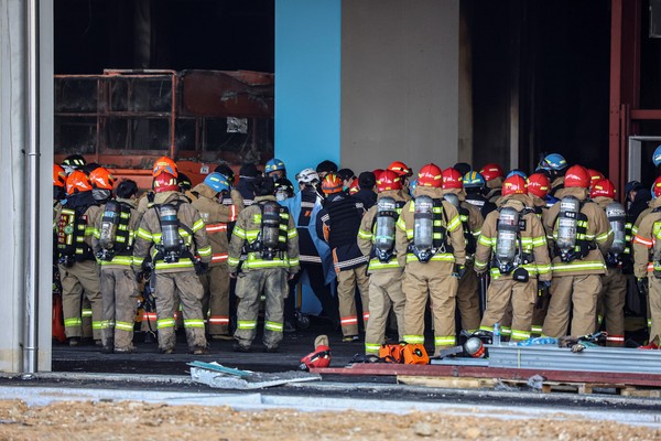 在京畿道平泽市某新建冷冻仓库工地进行灭火工作的3名消防员失踪，图为6日下午，被找到的失踪消防员正在被送往医院。【照片来源：韩联社】