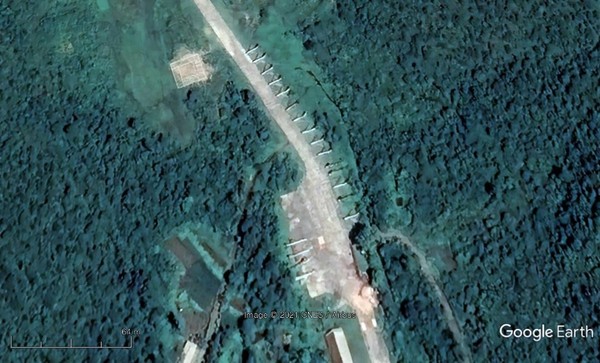 放大到黄海南道苔滩机场跑道附近的地下飞机库(上图圆圈)，发现机库入口处停着朝鲜战斗机。【图片来源：谷歌地球】