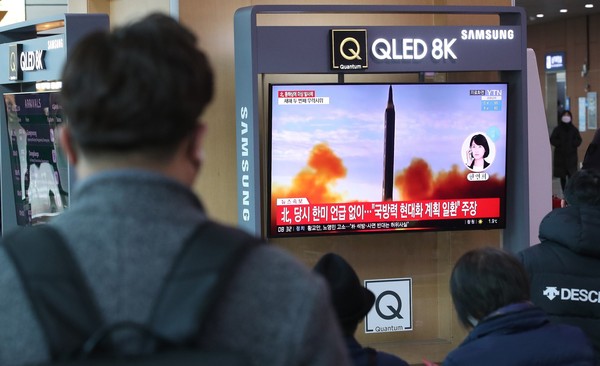 图为11日上午在首尔站的人们正在观看朝鲜发射导弹的相关新闻。【照片来源：NEWS1】
