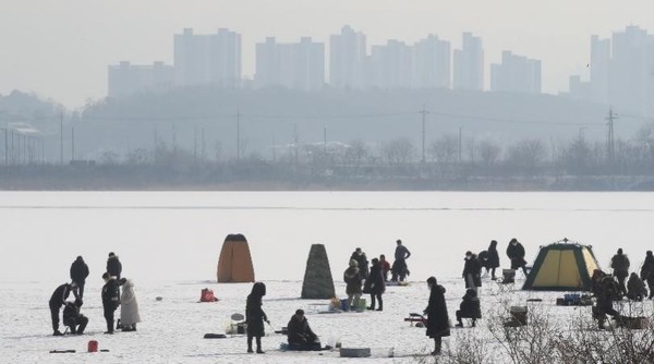 图为23日，在江原道春川市义岩湖享受冰钓的市民们。 【照片来源：韩联社】
