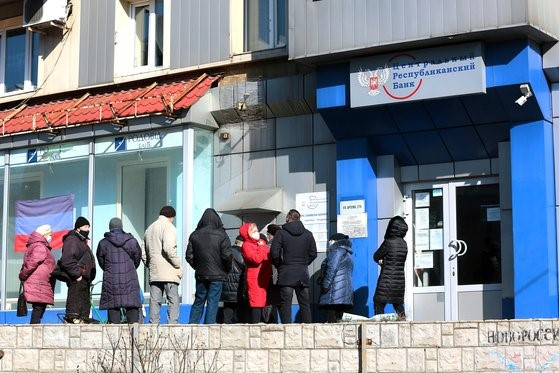 图为，当天在顿涅茨克市为提取存款而在自动取款机(ATM)前排队的人。【照片来源：美联社=韩联社】