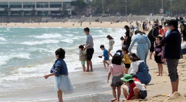 图为10日，来到釜山海云台海水浴场的市民们正在玩水。【照片来源：NEWSIS】