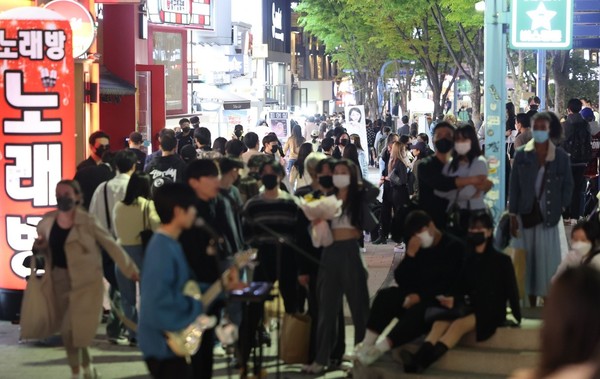图为17日下午，市民们正在首尔麻浦区弘大入口站附近观看街头表演。【照片来源：韩联社】