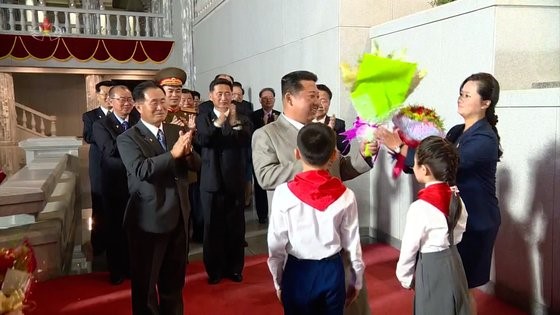 去年9月朝鲜政府成立纪念日活动上，金正恩国务委员长把收到的鲜花交给劳动党副部长玄松月。【照片来源：朝鲜中央电视台=韩联社】