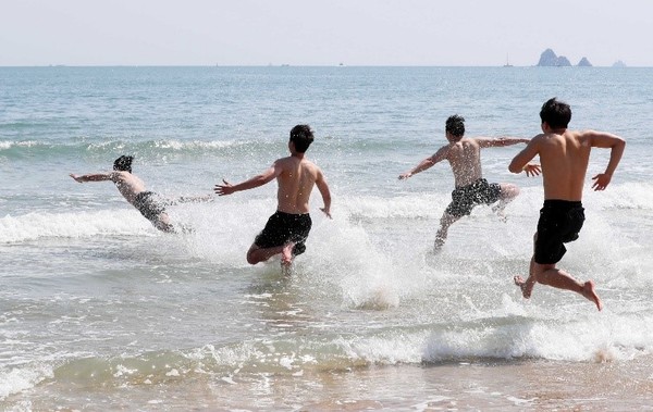 图为5月1日当天在釜山海云台海水浴场前奋力跑向大海的人们。【新闻来源：NEWSIS】