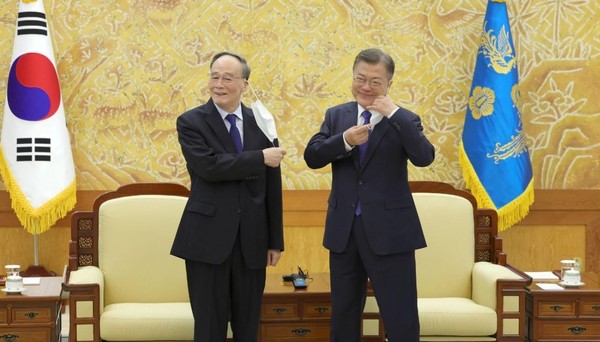 9日下午韩国总统文在寅在青瓦台本馆接见室与中国国家副主席王岐山合影前摘下口罩。