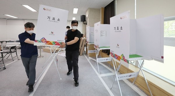 韩国第8届全国同时地方选举提前投票还剩两天，图为25日下午在首尔松坡区可乐1洞居民中心的工作人员正在设置提前投票站。地方选举的提前投票将在27、28日两天进行。【照片来源：韩联社】