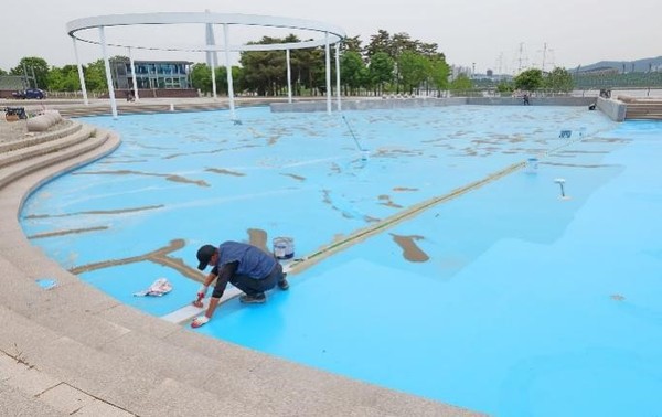 图为25日下午，在首尔广津区纛岛汉江公园游泳场，汉江事业本部的工作人员正在对游泳场进行清洁。汉江事业本部正在对过去2年因新冠肺炎而被限制运营的汉江公园一带的游泳池和水上乐园进行整顿，目标是下月25日开张。本部计划在工作结束后，通过首尔市网站发布营业公告。开放的汉江游泳场有广渡口、蚕院、汝矣岛、纛岛、杨花、兰芝等6处。【照片来源：韩联社】