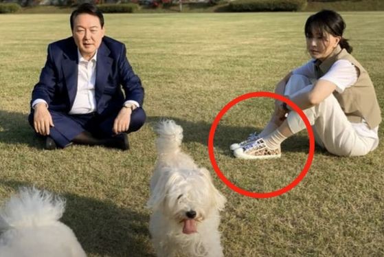 图为韩国总统尹锡悦和夫人金建希女士在首尔龙山总统办公室前的草坪上与爱犬一起度过愉快时光。很多网友猜测金建希女士脚上蹬的是法国奢侈品牌“迪奥”的运动鞋，从而再次引发网友关注。【照片来源：金建希女士粉丝团“爱建希”脸书】