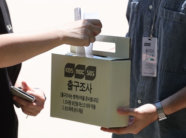 图为6月1日，第8届韩国全国地方政府选举投票日当天下午，在首尔永登浦区永同小学投票所的一位选民正在参与出口民调。