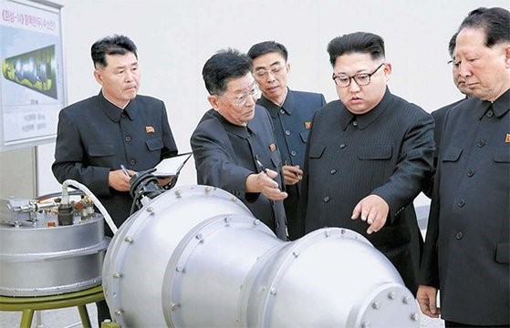 图为朝中社2017年9月3日公开的朝鲜国务委员长金正恩现场指导核武器兵器化工作的照片。照片中有一个物体看起来像是长鼓形态的核爆炸装置，可以看到左侧上方写有“火星-14型核弹头(氢弹)”字样。【照片来源：朝中社】