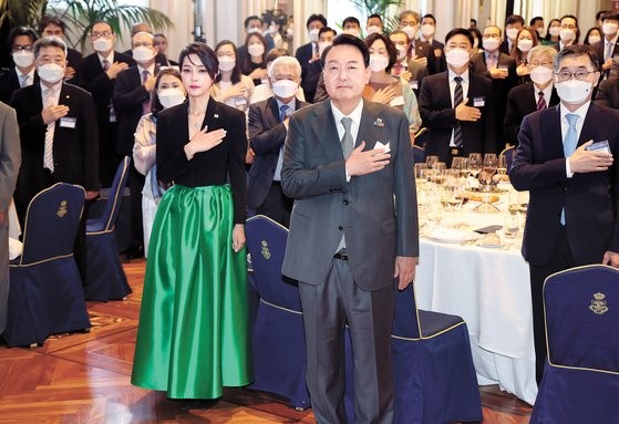 图为当地时间6月29日，在西班牙马德里的马德里丽兹文化东方酒店(Mandarin Oriental Ritz)举行的韩侨晚餐座谈会上，尹锡悦总统和金建希女士正在向国旗敬礼。【照片来源：韩联社】