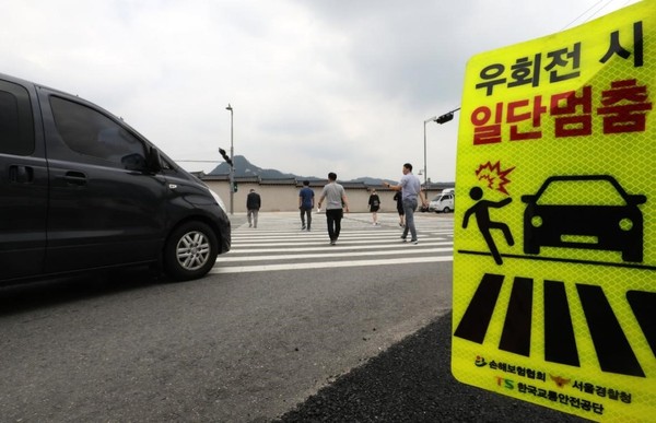 7月11日，在修订后的《道路交通法》实施前一天，首尔的一个交叉路口设置了”右转必停”标志。根据韩国修订后的《道路交通法》，所有驾驶员不仅在通过人行横道时需暂时停车，在行人“想要通行时”也要暂时停车。另外，在儿童保护区域内未设置信号灯的人行横道上，无论行人是否通行，都必须暂时停车。若违反规定，将对相关车辆驾驶员处以6万韩元的罚款和驾驶证扣分10分。【照片来源：NEWS1】