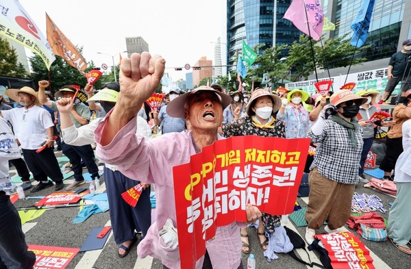 图为7月12日，在首尔站前举行的阻止加入《全面与进步跨太平洋伙伴关系协定》(CPTPP)国民大会上，与会者正在高喊口号。与会者称，如果韩国加入CPTPP，农水产品进口将大幅增加，韩国国内农水产行业将不可避免地遭受损失，因此要求取消加入。韩国农村经济研究院(KREI)也预测称，韩国加入CPTPP后的15年间，农畜产业年均损失将达853亿-4400亿韩元。【照片来源：韩联社】